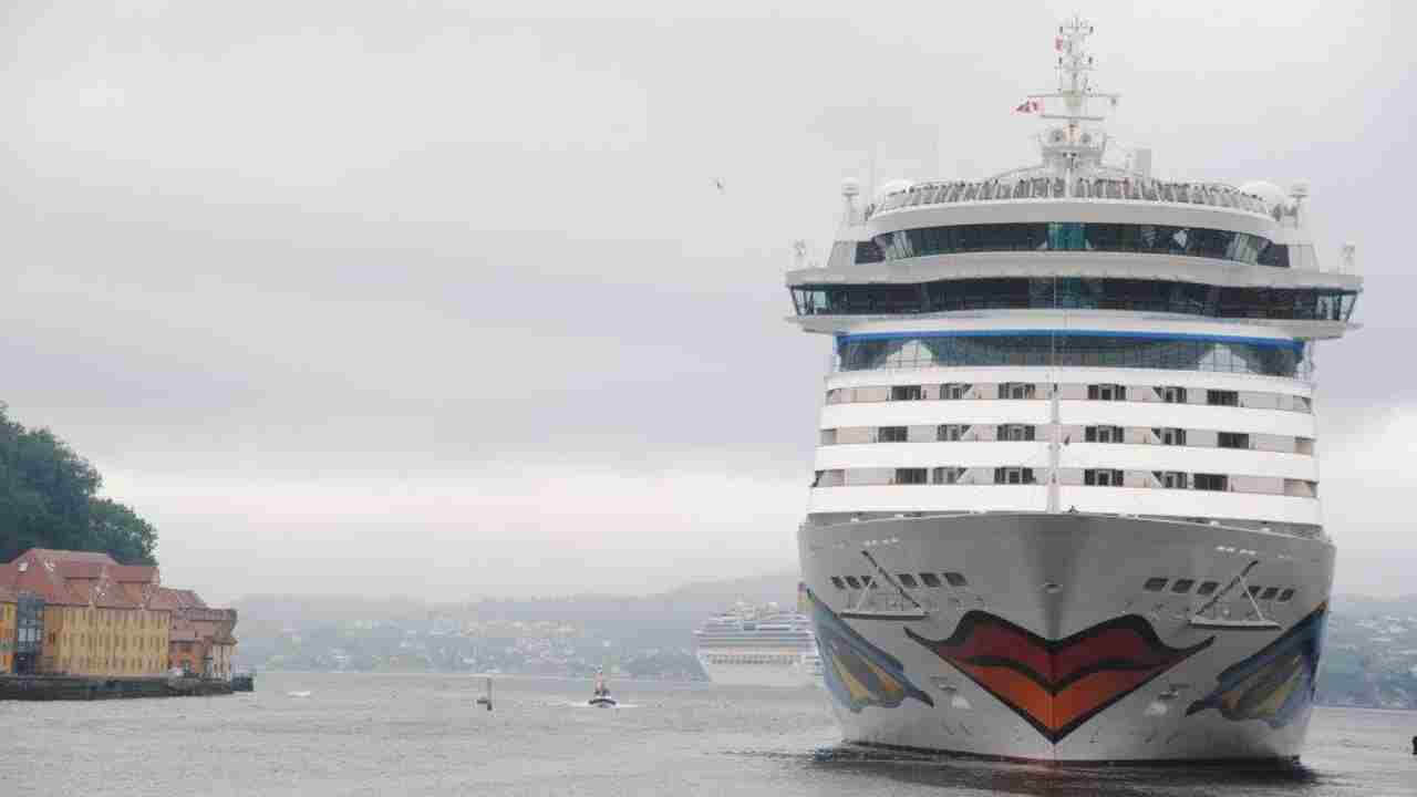 a cruise ship is docked in a harbor on a cloudy day