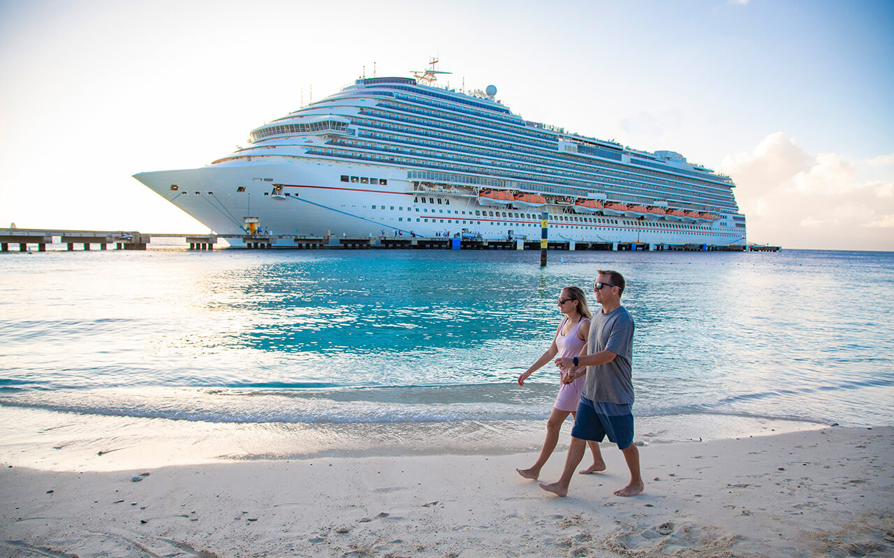 Couple walking in front of a cruise ship