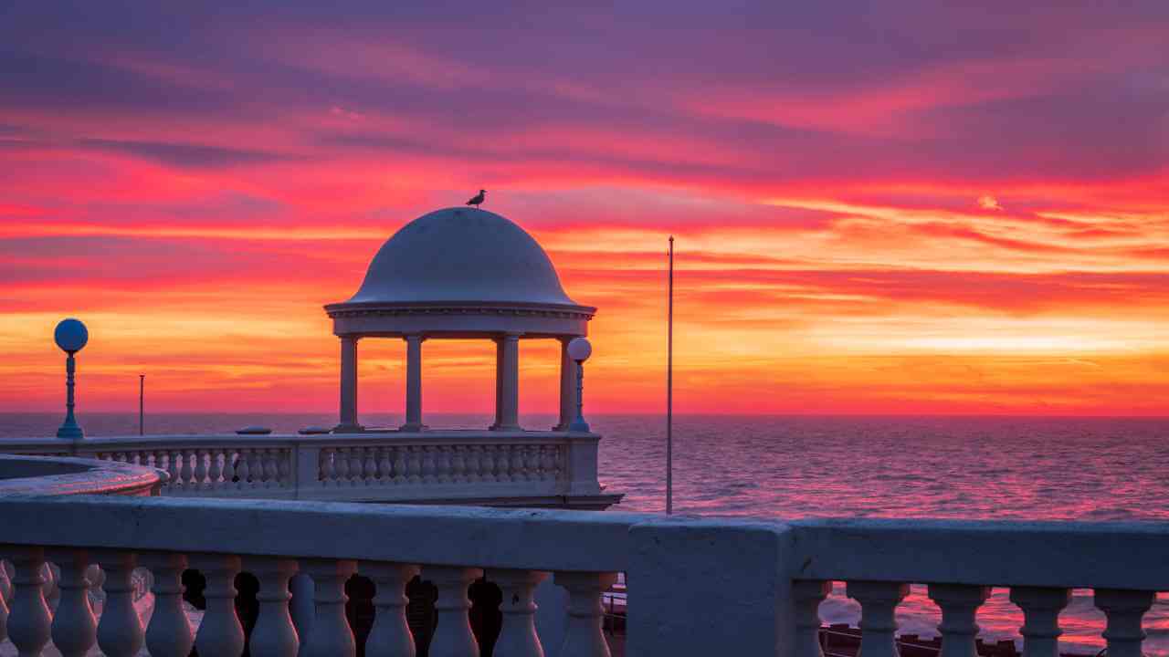 a gazebo overlooking the ocean at sunset