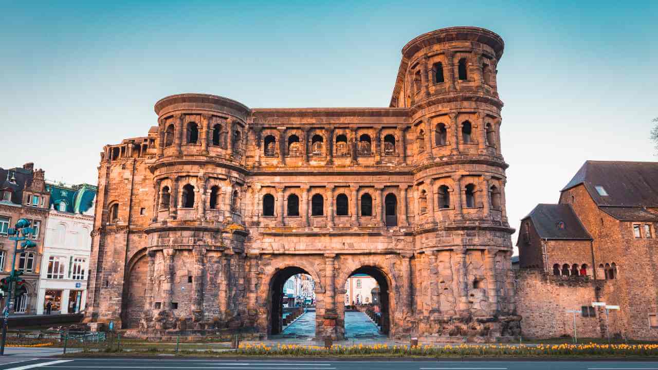 an old stone archway in the middle of a city