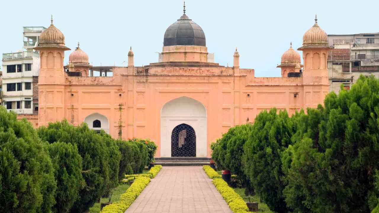 a large pink building with two domes on top of it