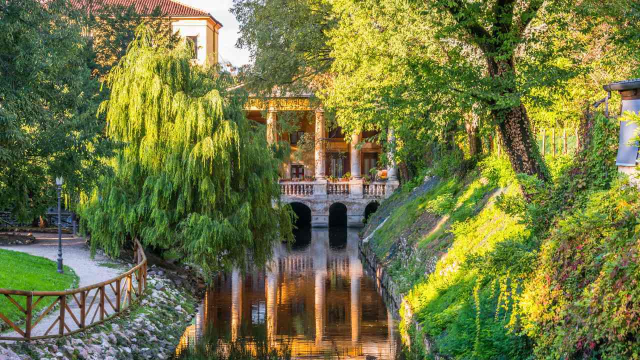 a canal in the middle of a lush green park