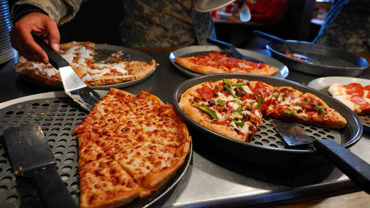 several pizzas are being served on trays