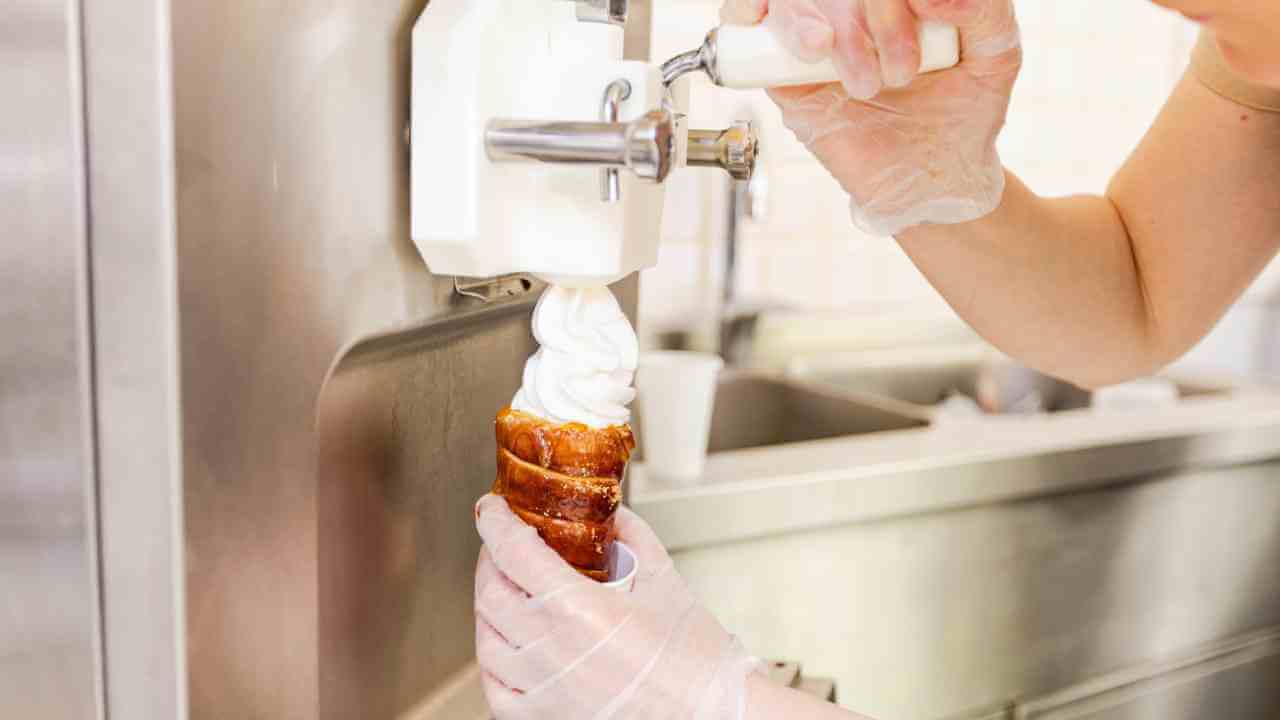 a person in a white glove is holding an ice cream cone