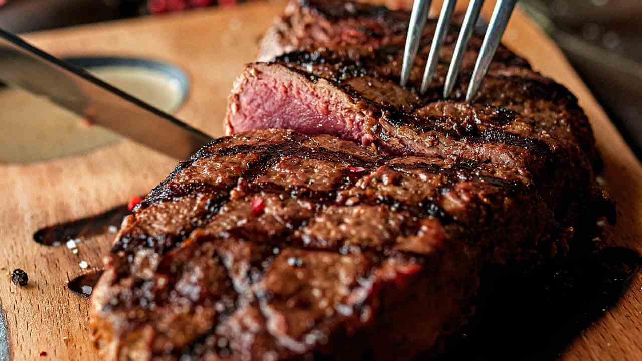 a piece of steak on a cutting board with a fork