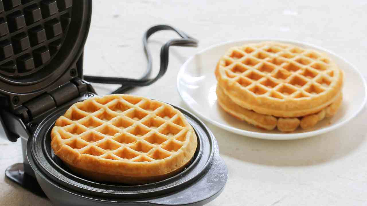 a waffle maker with two waffles sitting on top of it