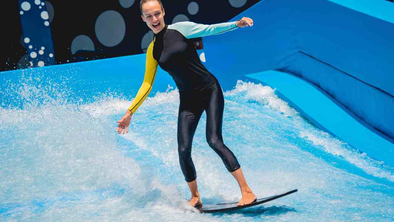 a person in a wetsuit riding a wave on a surfboard