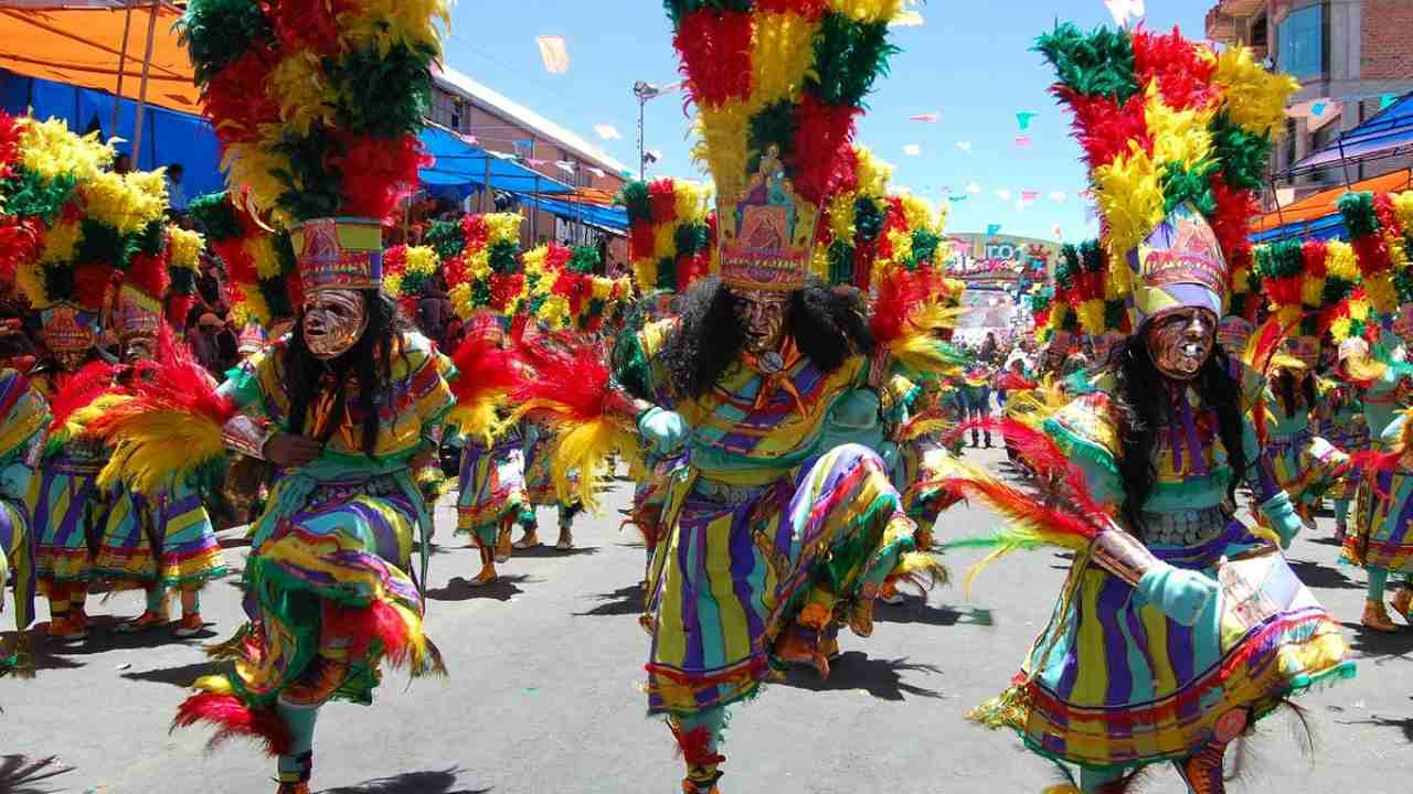 a group of people in colorful costumes dancing in the street