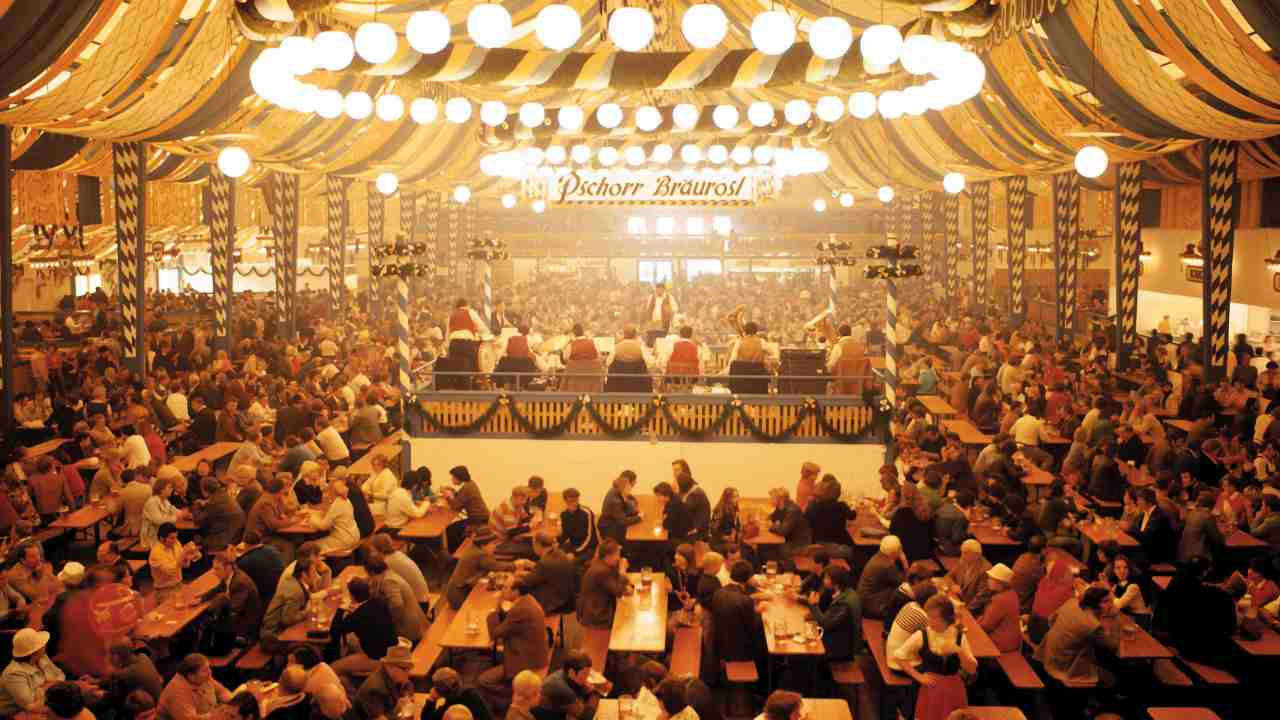 a large group of people sitting at tables in a tent