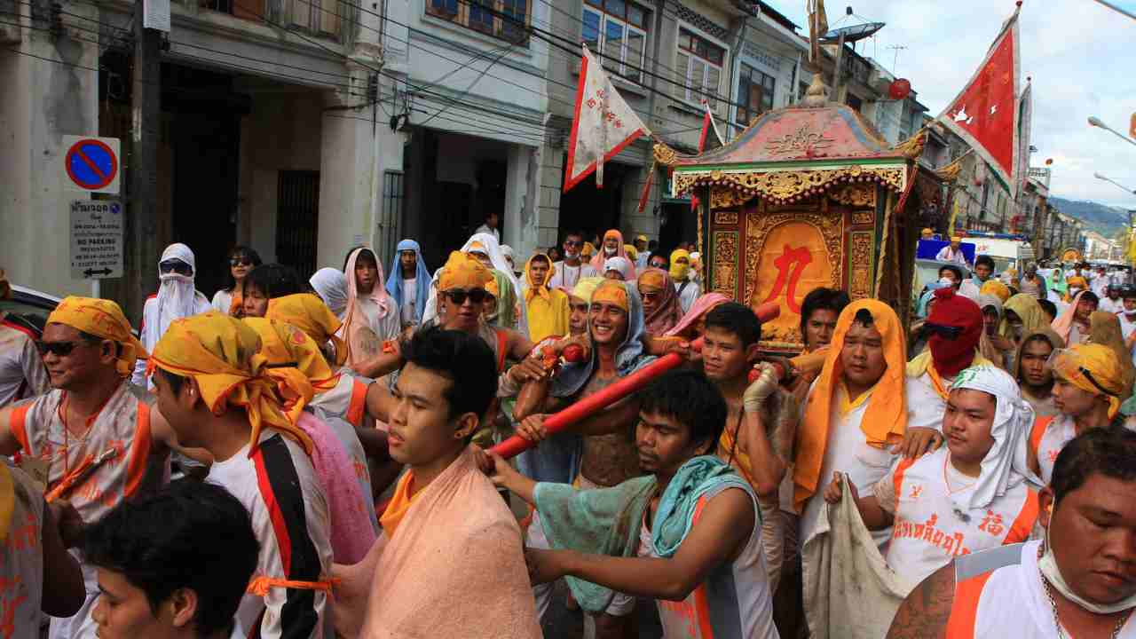 a large group of people dressed in orange and white walking down the street