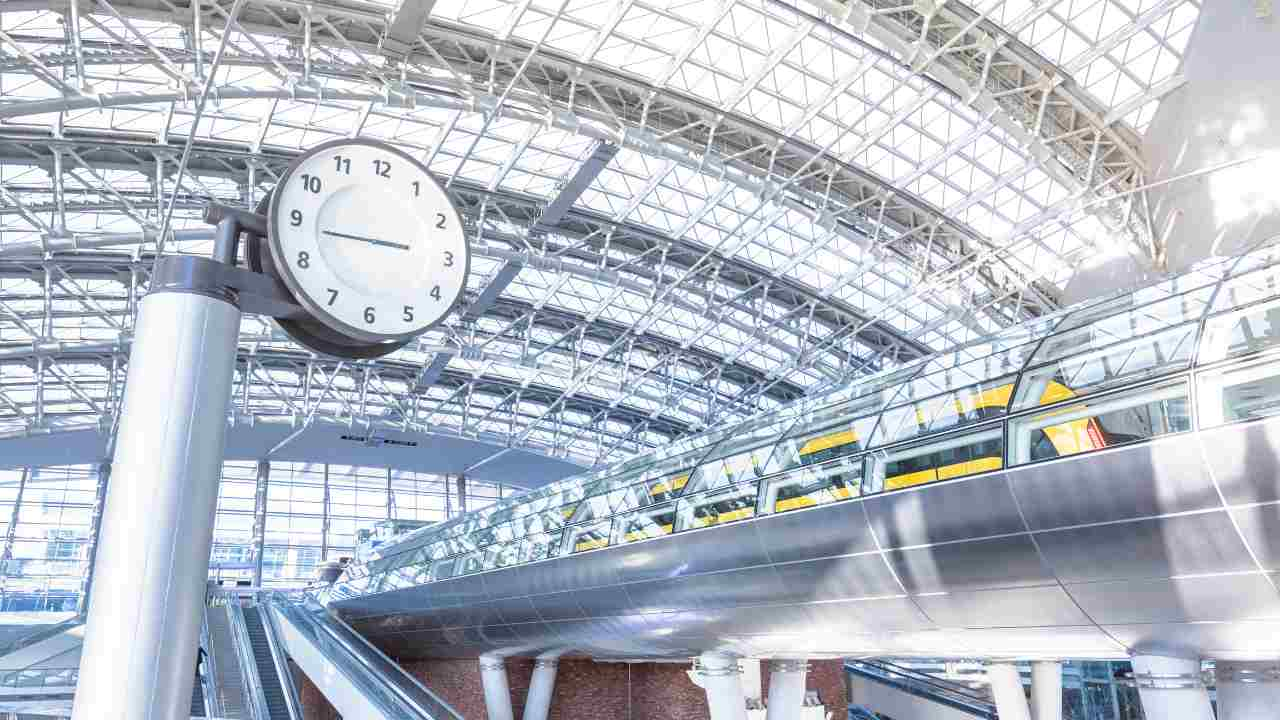 an escalator at a train station with a clock on it