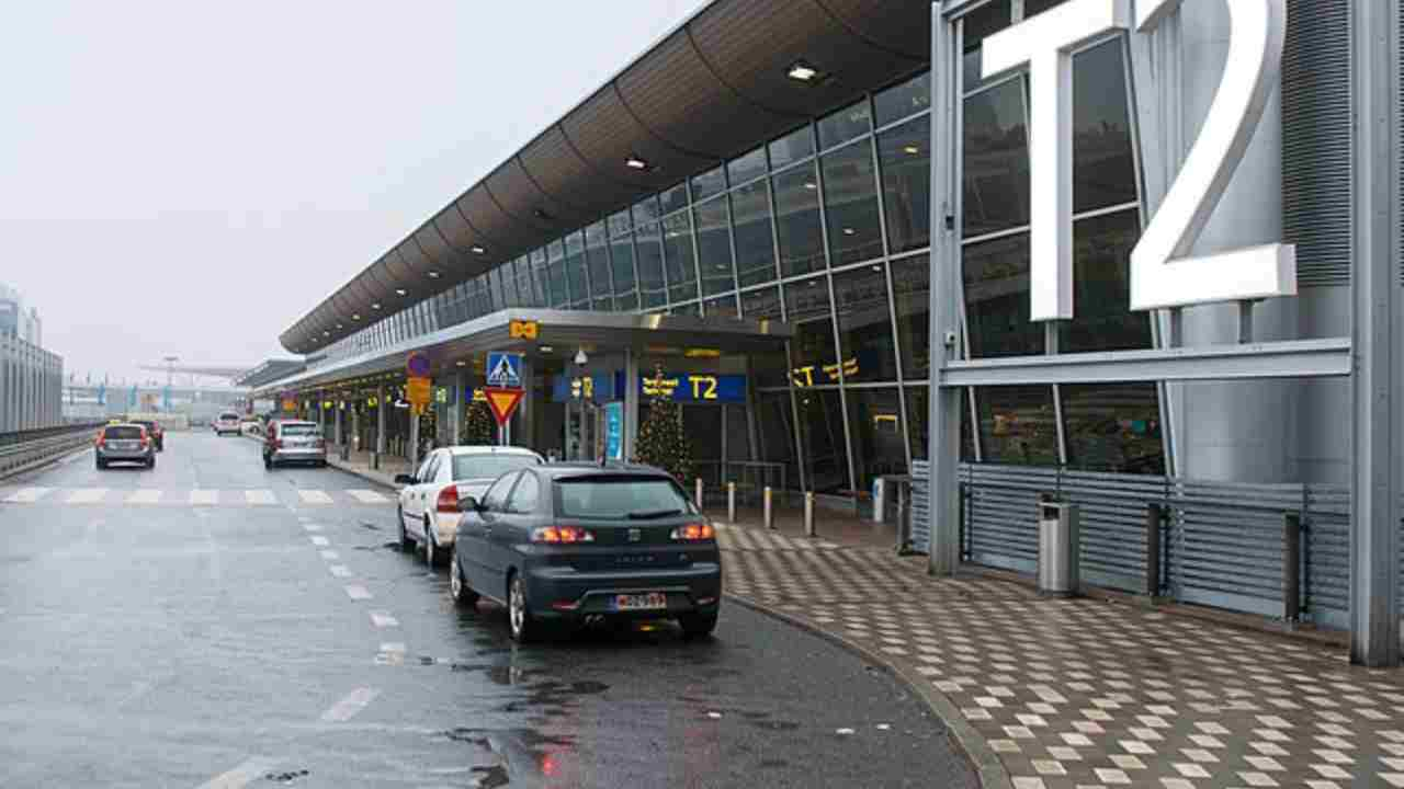 a car is parked in front of an airport terminal