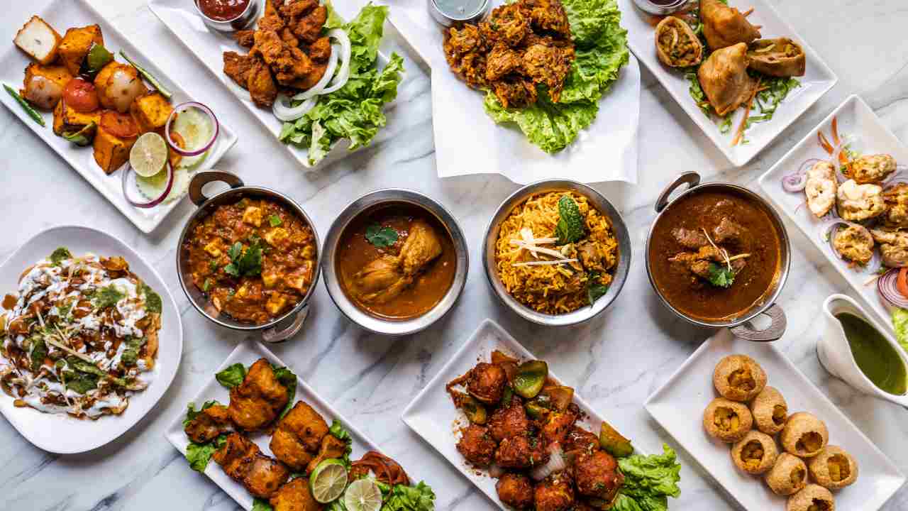various types of indian food on white plates