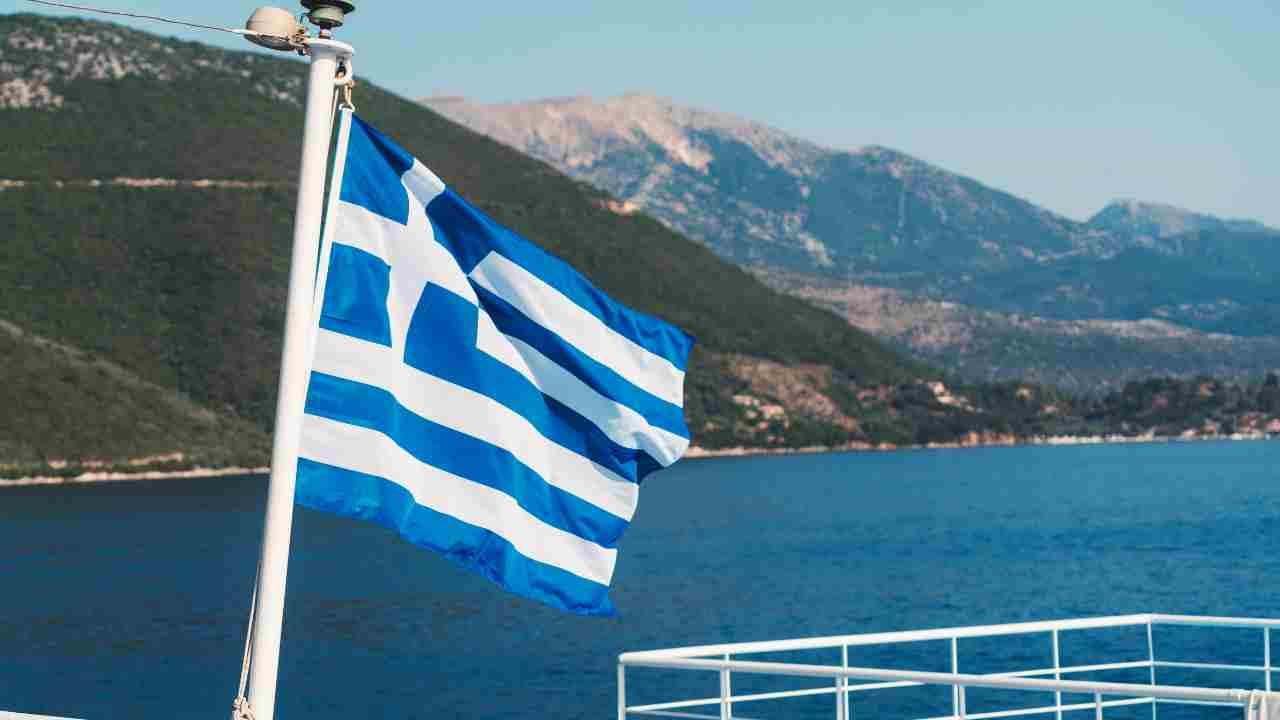 A flag on a boat in the sea with mountains in the background - Greece stock videos & royalty-free footage