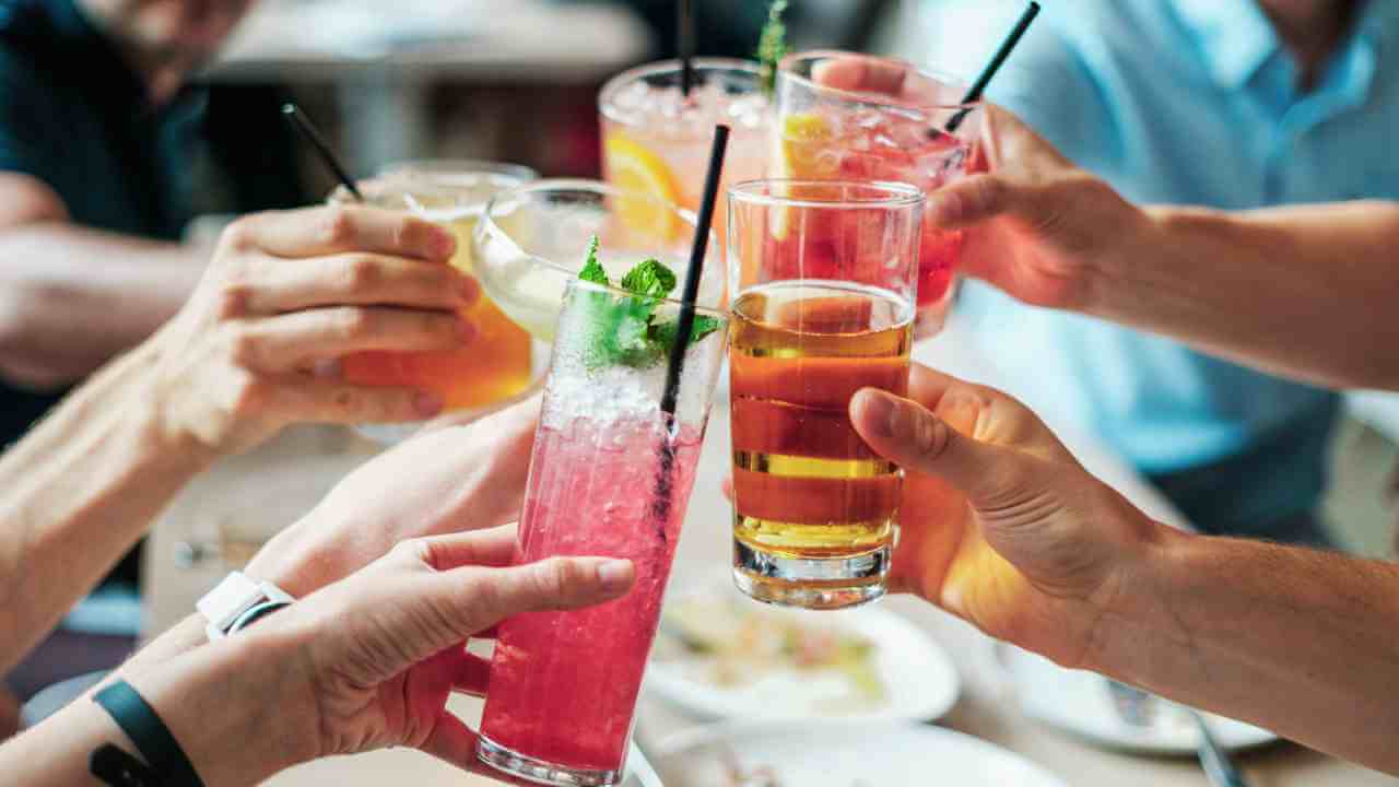 a group of people toasting with drinks at a restaurant