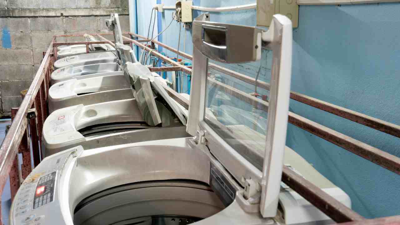 a row of washing machines in a laundry room