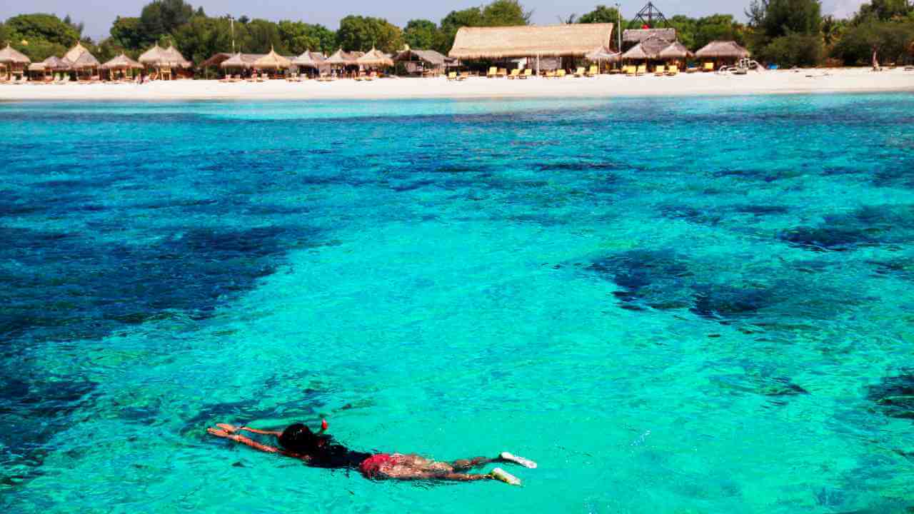 a person snorkeling in the clear waters of a tropical island