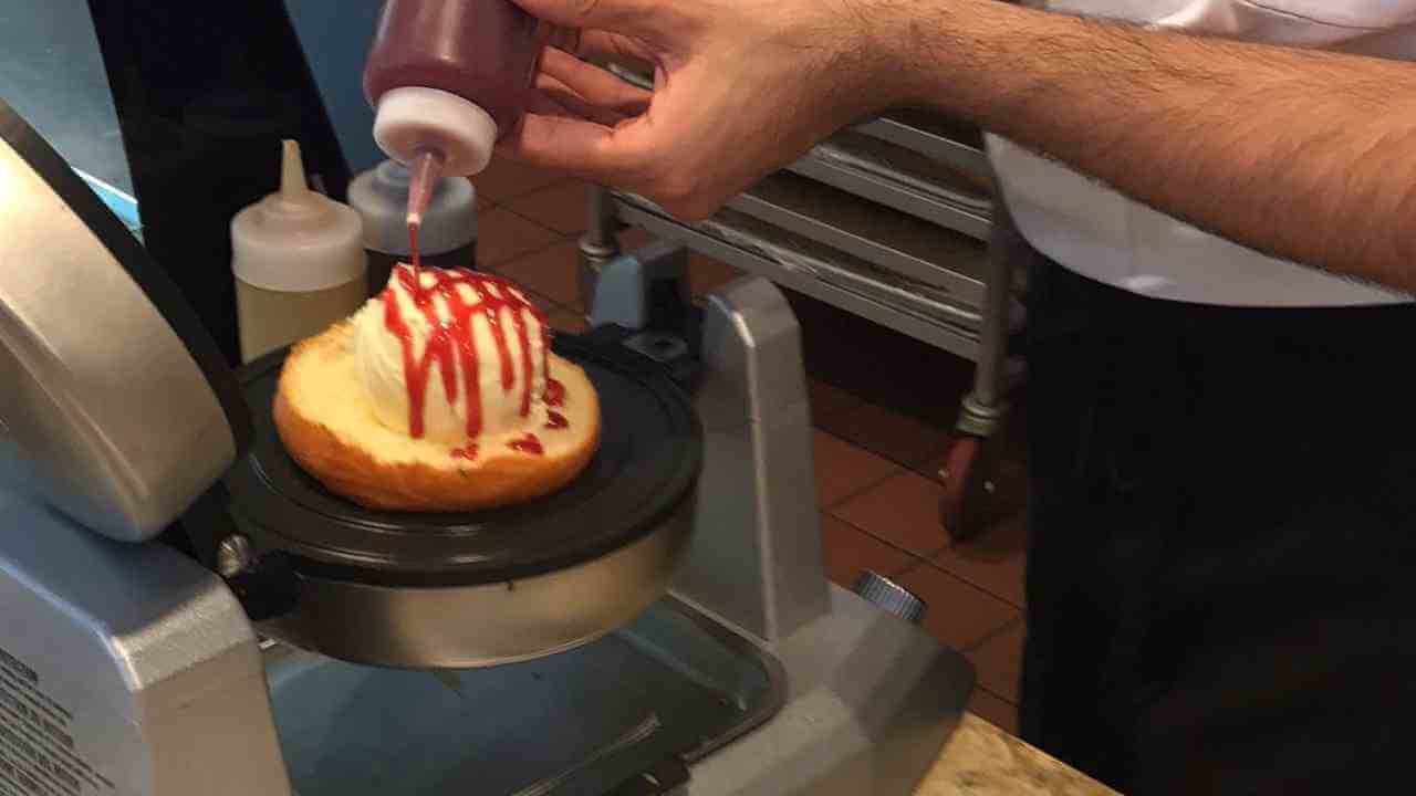 a person is making a donut in a waffle maker