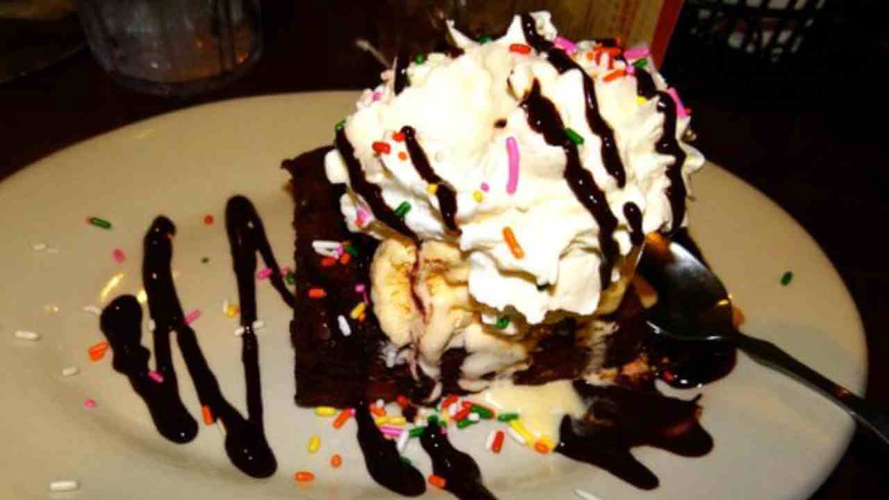 a piece of chocolate cake with ice cream and sprinkles