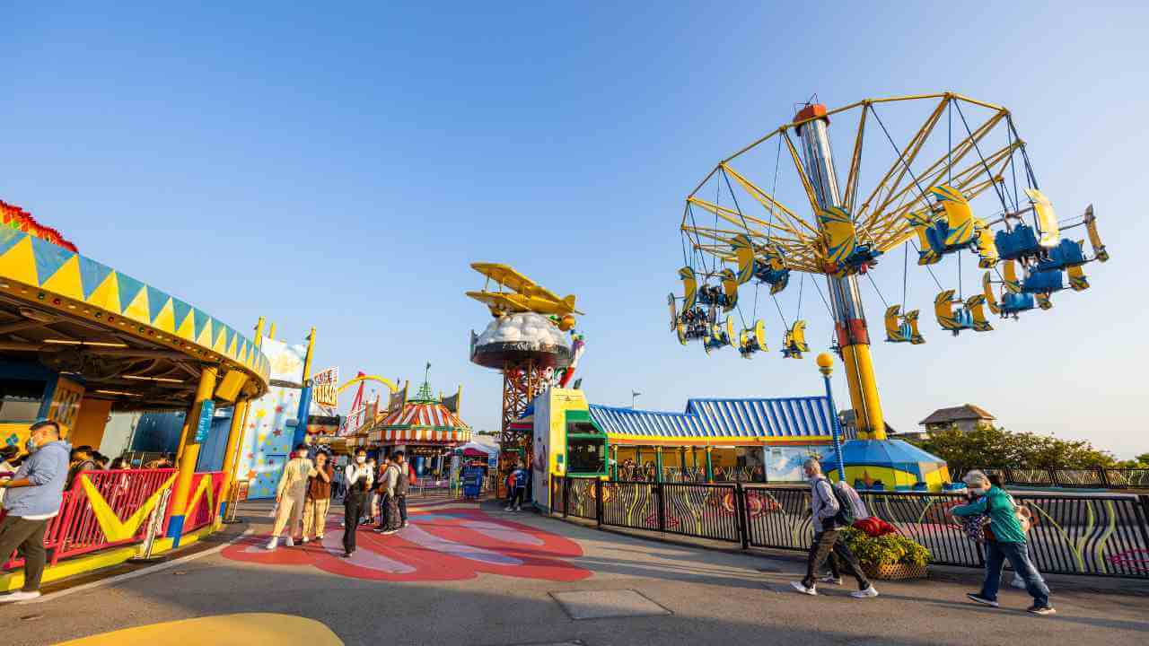 an amusement park with rides and people walking around