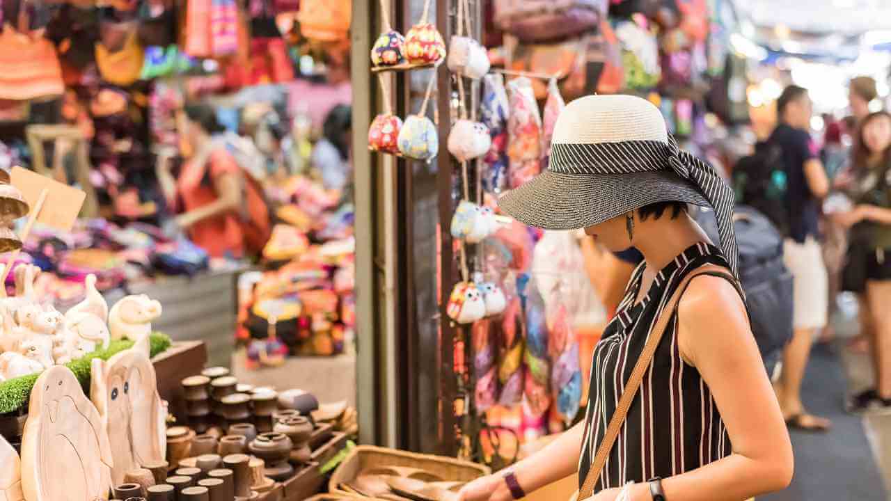 a person in a hat is looking at items at a market