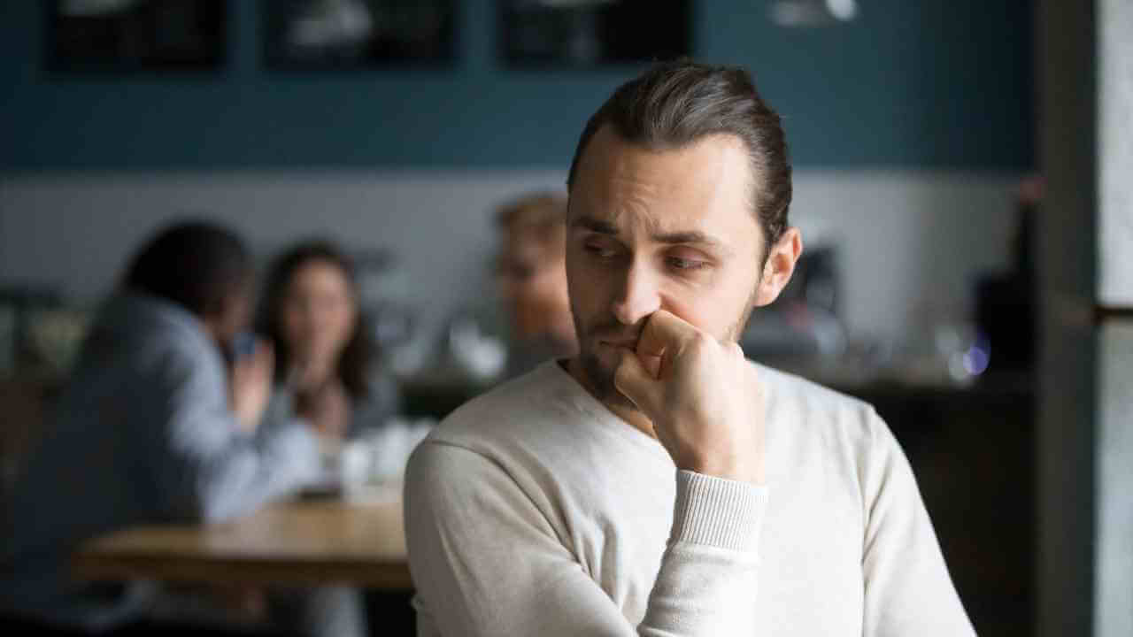 a person sitting at a table with their hand on their chin