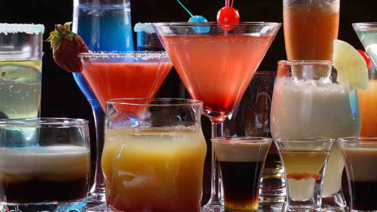 Various types of alcoholic drinks in glasses on a table