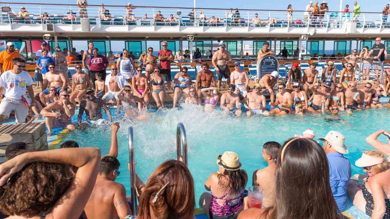 a crowd of people in the pool on a cruise ship