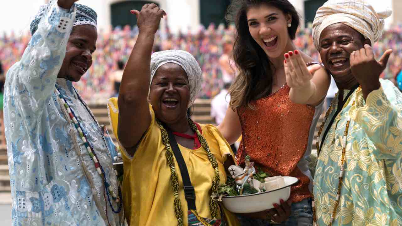 Three people pose for a picture with their hands in the air.