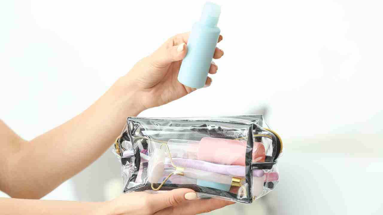 a person is holding a clear bag with makeup products in it