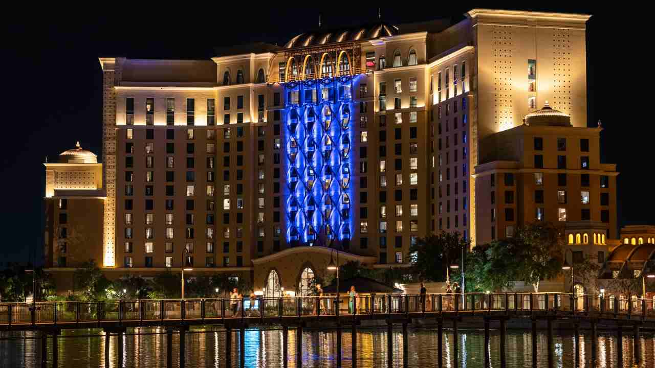 the hotel is lit up at night with blue lights