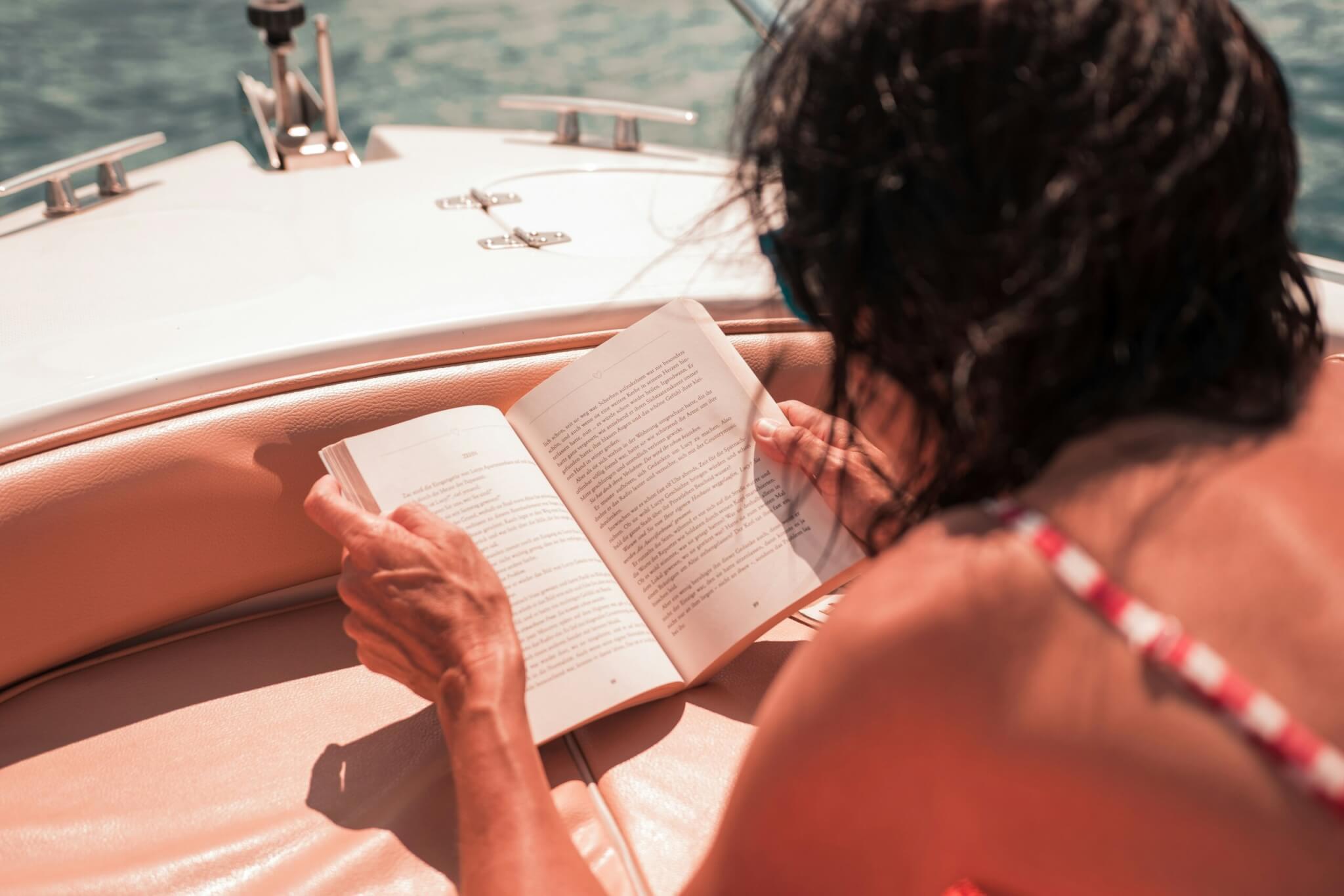 woman reading a book on a boat