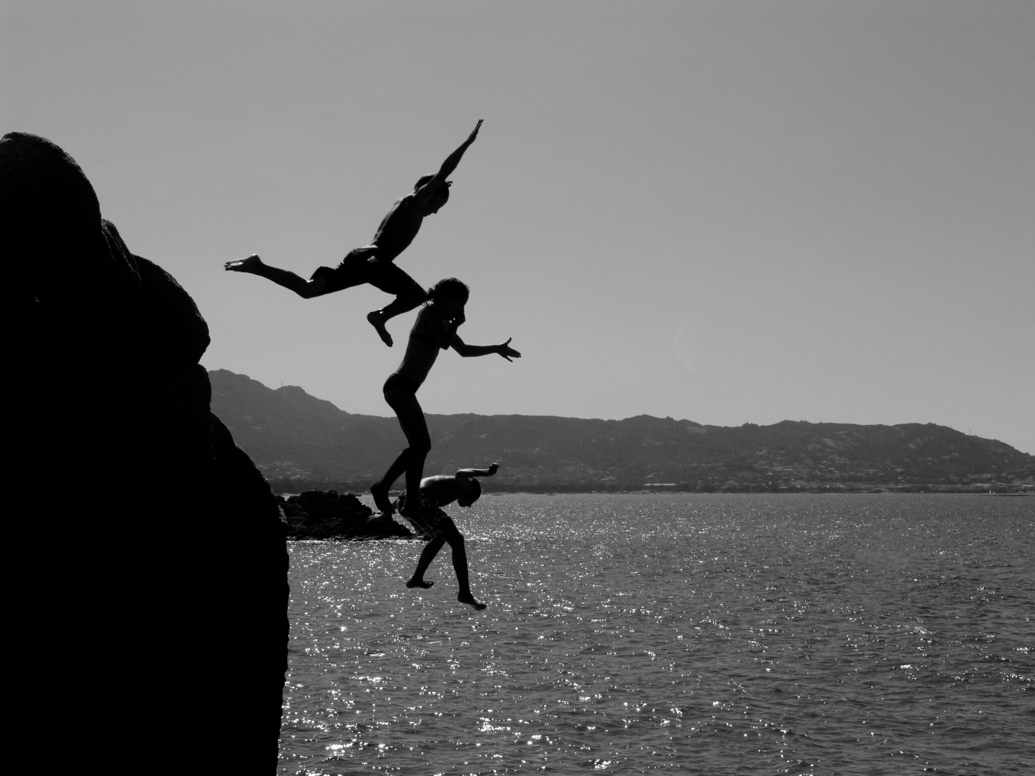 people jumping off a cliff