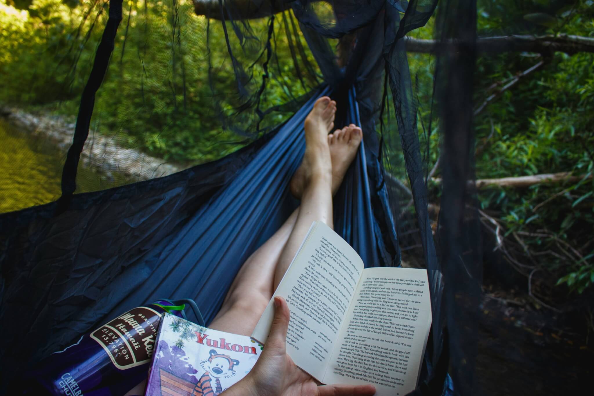 person reading a book on a hammock