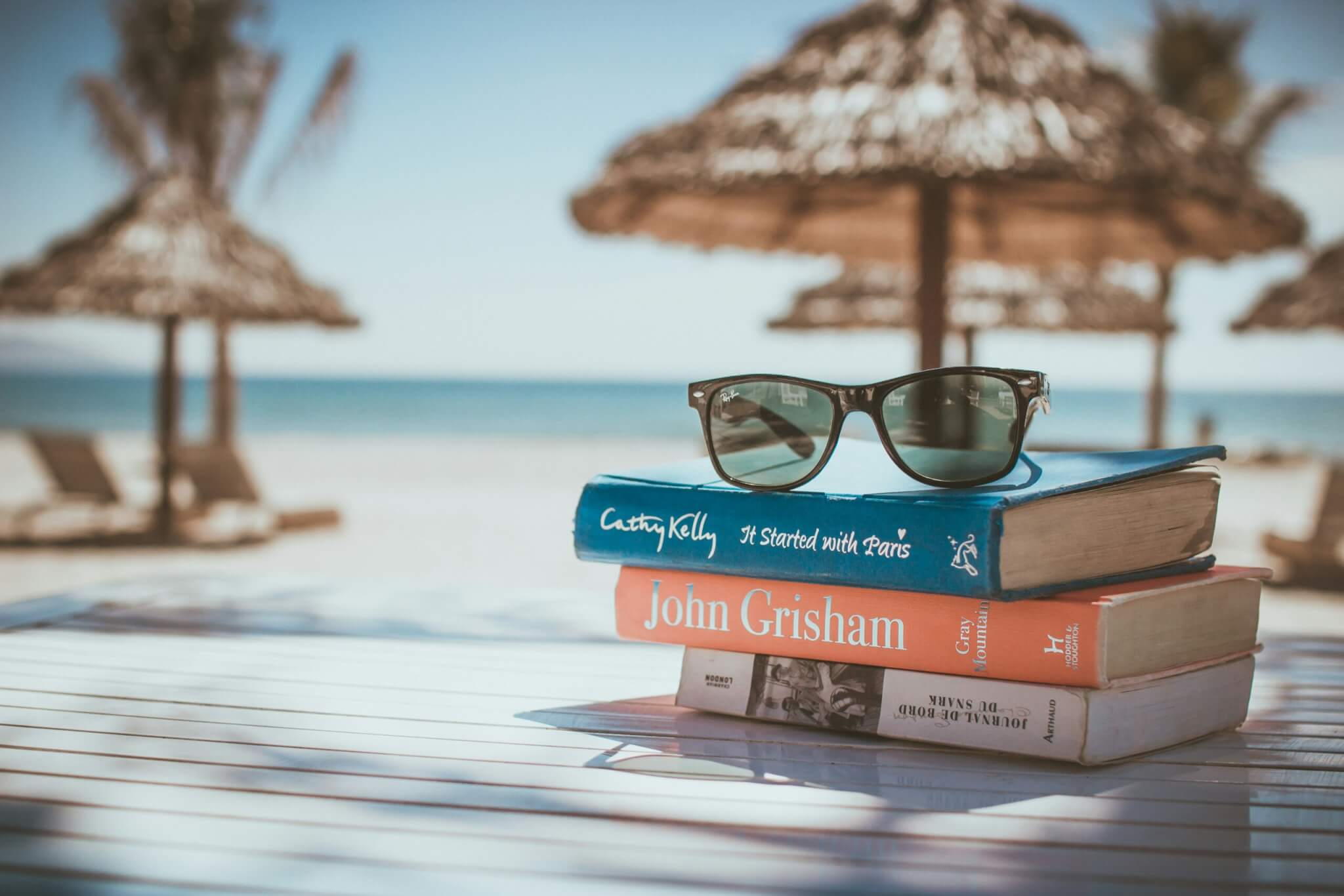 stack of books with sunglasses