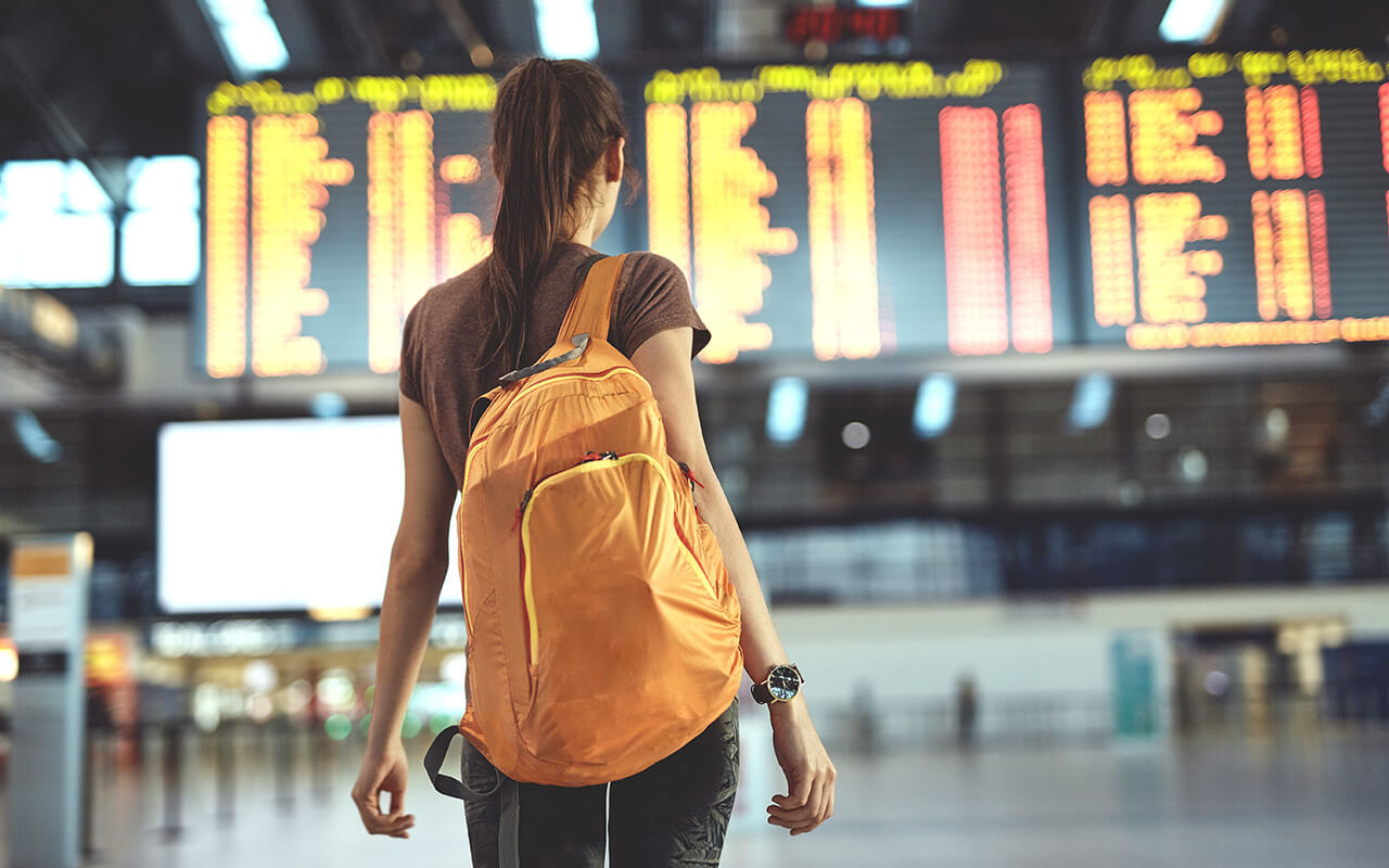 Woman walking through the airport with a backpack