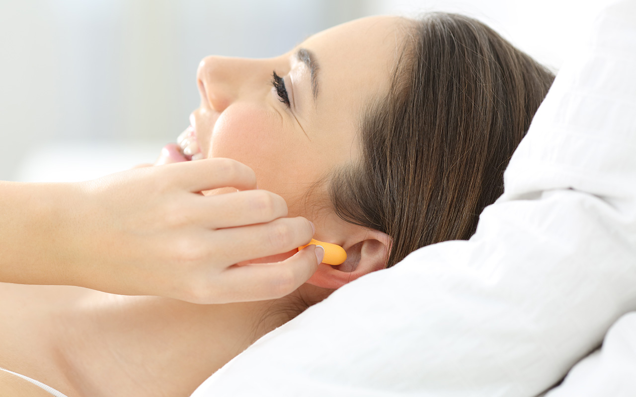 Woman putting ear plugs in 