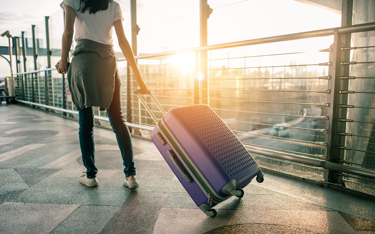 woman walking through the airport with her luggage