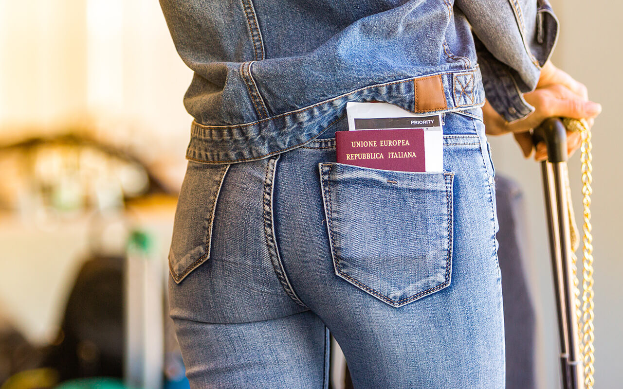 Woman wearing jeans with a passport in her back pocket