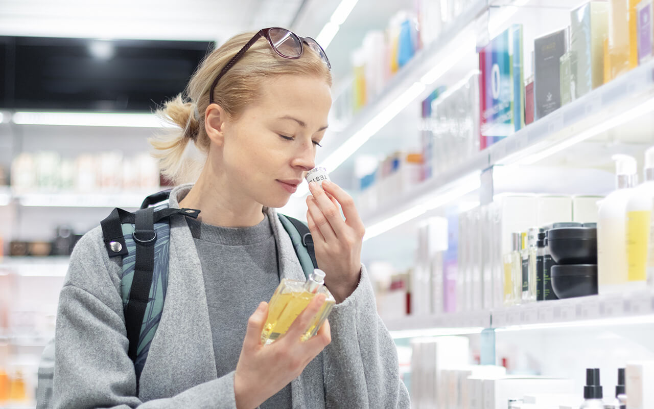 woman sniffing perfume in a store