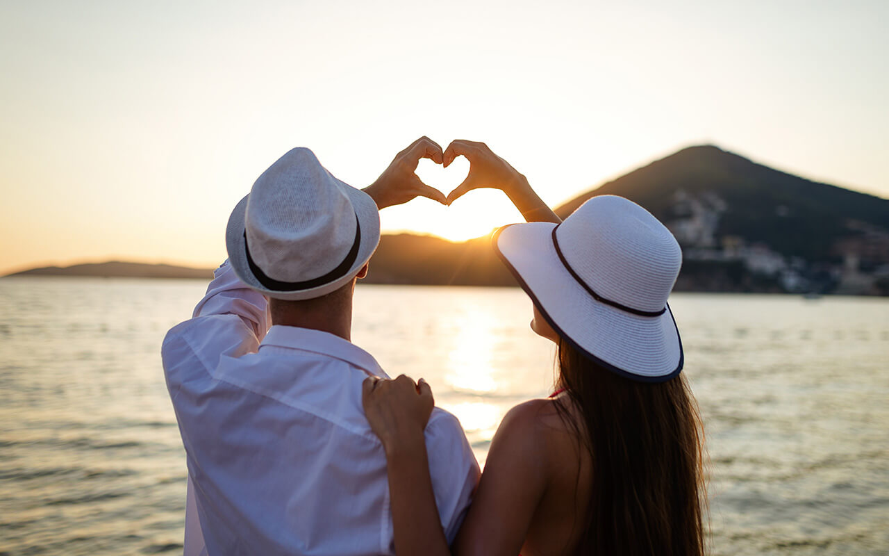 Happy couple in love walking on beach on honeymoon vacation