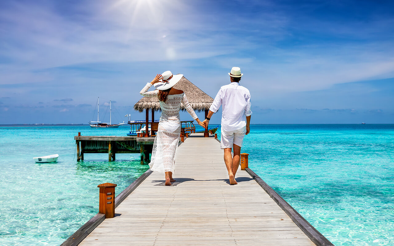 Couple walking on a pier overlooking the ocean