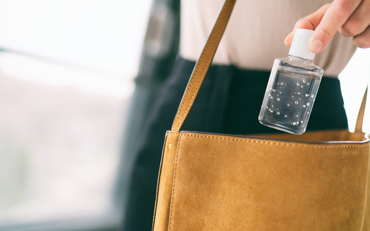 Woman putting hand sanitizer in her purse 