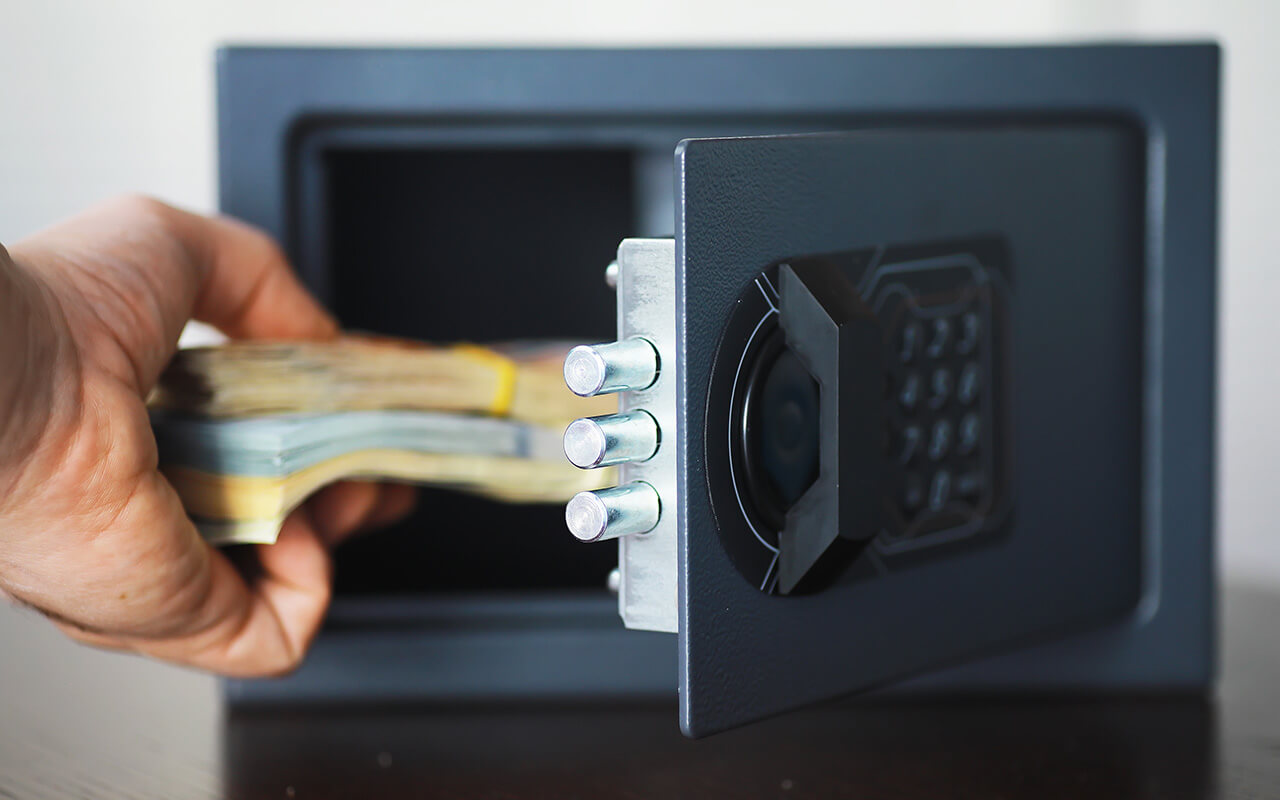 Person putting cash in a hotel safe