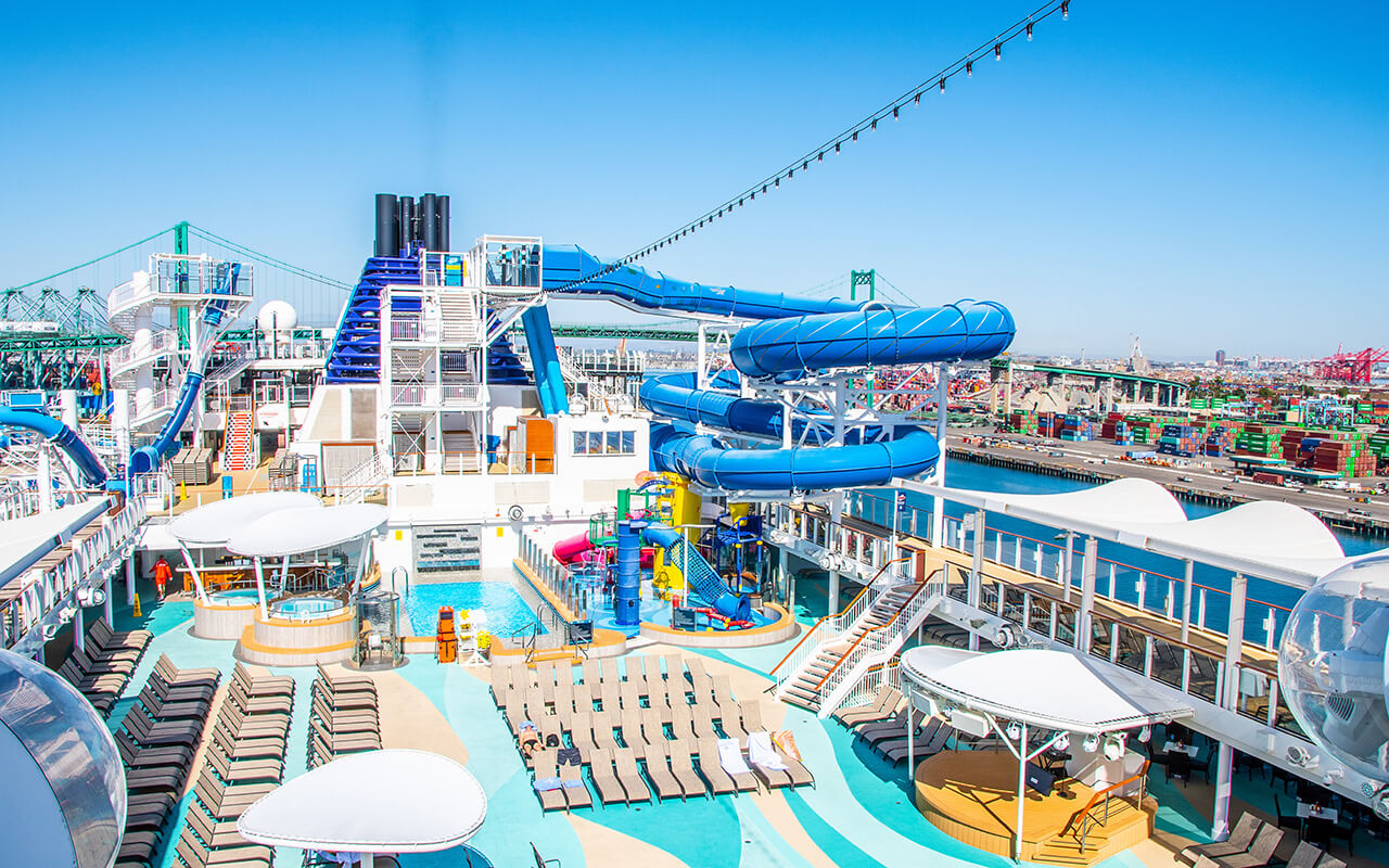 Empty sun deck on Norwegian (NCL) Joy Cruise Ship with waterslides, pools, hot tubs and lounge chairs for sunbathing. 