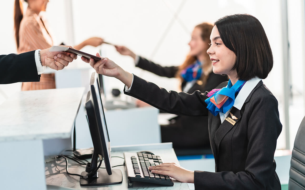 Woman handing flight passenger their ticket