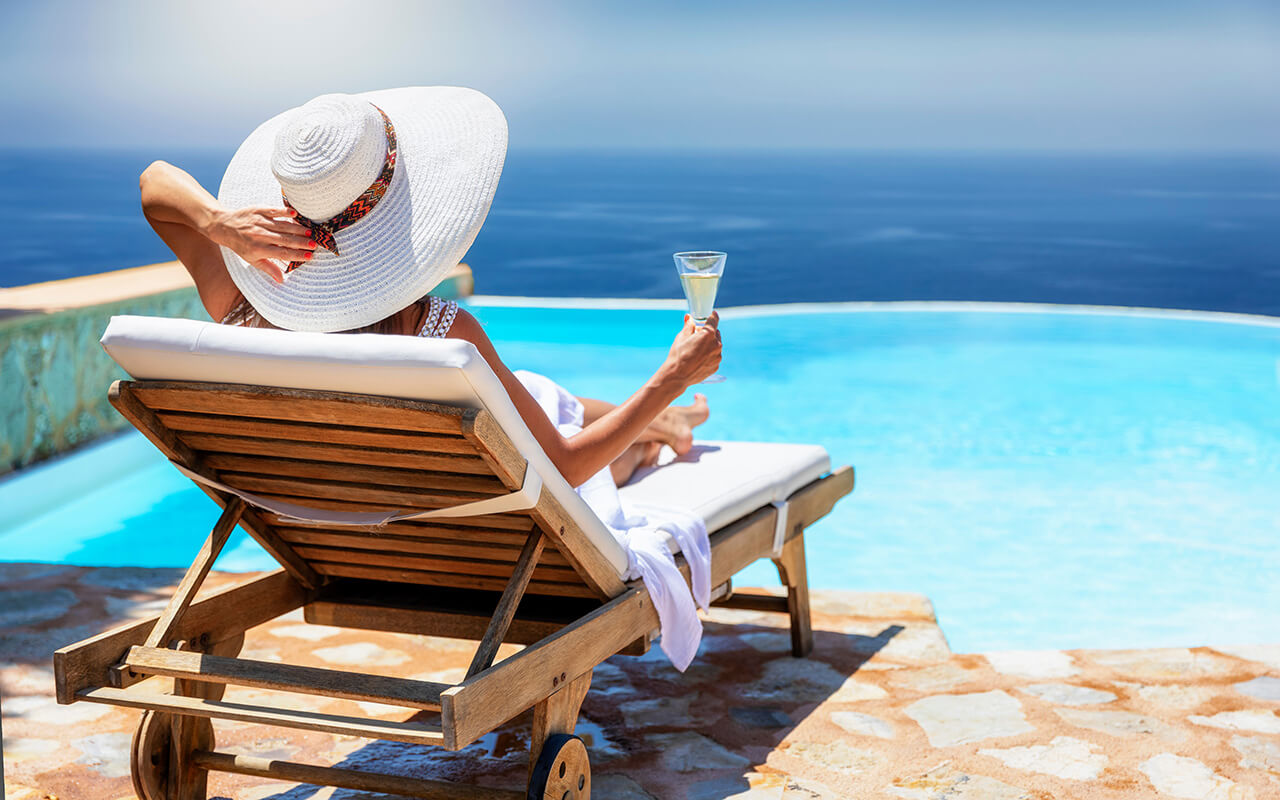 Woman lounging by the pool with a drink