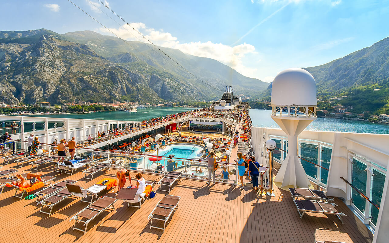 Tourists on a large cruise ship on Boka Bay near Perast heading towards the Kotor Montenegro cruise port on the Adriatic Sea.