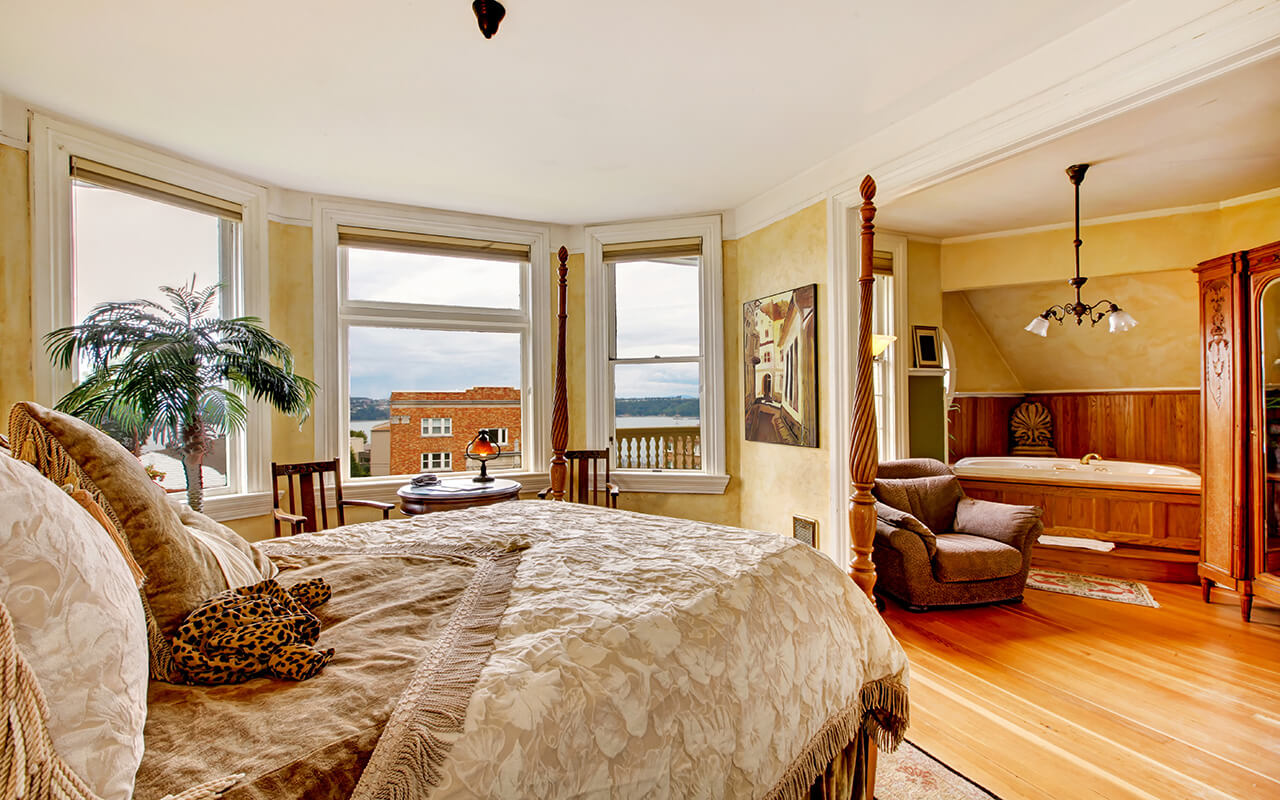 Large historical Inn room interior - bedroom with antique bed.