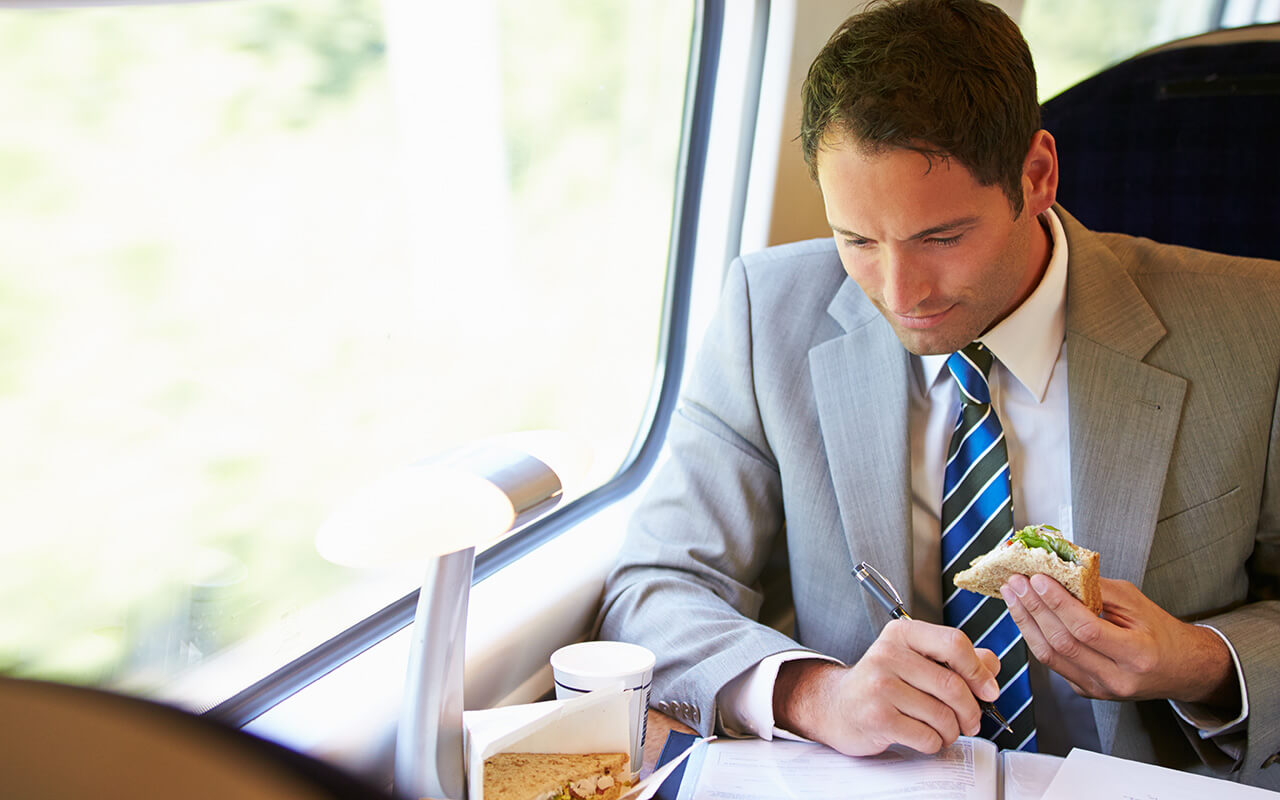 Man eating a sandwich on a train